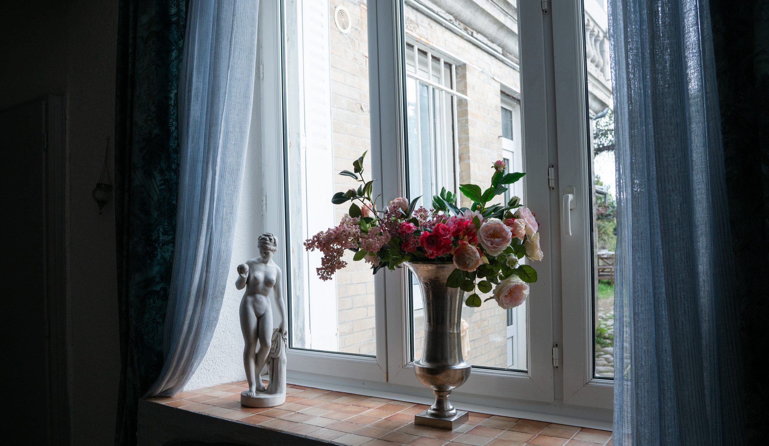 Fleurs dans un vase sur fenêtre.